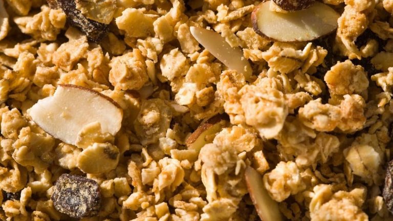 A close-up of granola clusters with sliced almonds